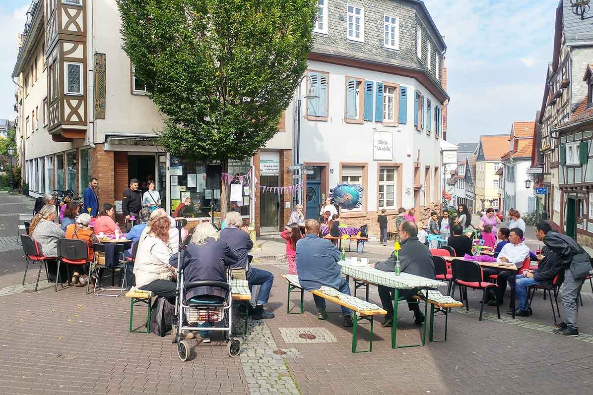 Bild mit dem Fünf-Fingetreff in der Altstadt und Gästen an Biergarnituren bei einem Fest auf dem Fünf-Finger-Platz.